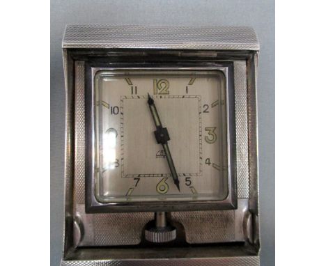 An art deco style silver cased travel clock by A Wilcox, Birmingham 1937, the folding rectangular case with engine turned dec