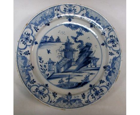 Three mid 18th century Delft blue and white dishes, variously painted with Chinese islands, the largest 37cm (14.5 in) diamet