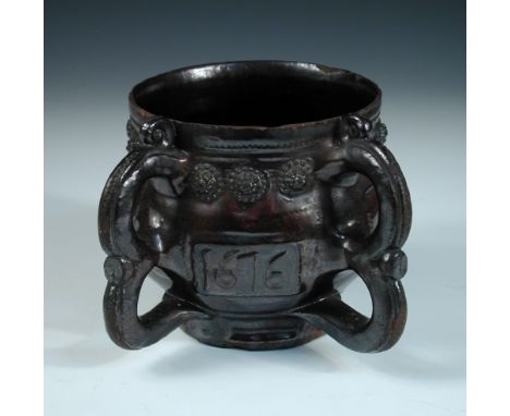A Wrotham dark treacle glazed two handled posset pot, dated 1676, the barrel shape initialled EW and I.I, for the potter John