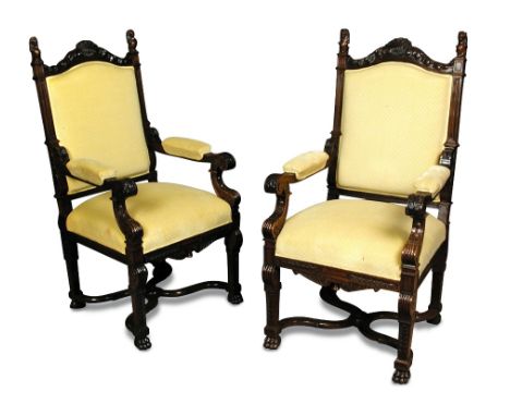 A pair of Edwardian rosewood armchairs, with lion rampant finials, carved architectural scroll decorated frames, upholstered 
