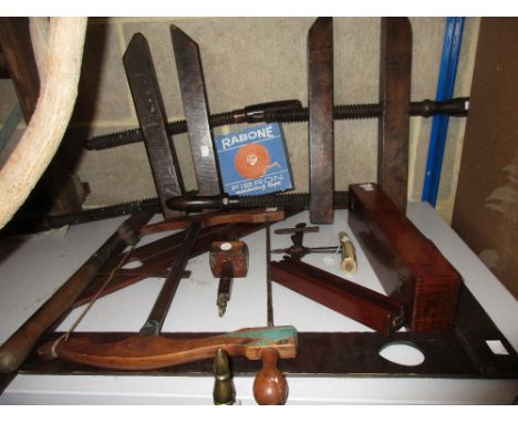 A quantity of wooden tools, set squares and clamps, to include: an 18th century fruit wood handled saw, pair of clamps closin