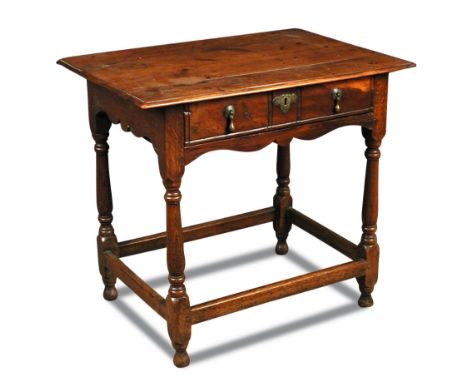 A William and Mary yew wood side table, with a plank top and moulded edge, the drawer with a half round moulding, brass drop 