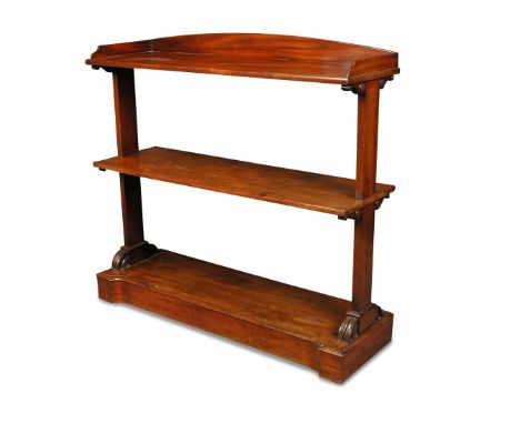 A late Regency mahogany dumb waiter, the top shelf with a three quarter gallery, two further shelves below with standard end 