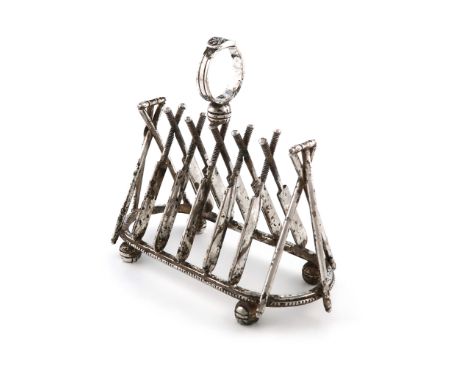 A novelty electroplated seven-bar toast rack, unmarked, the bars modelled as crossed cricket bats, the ends with crossed stum