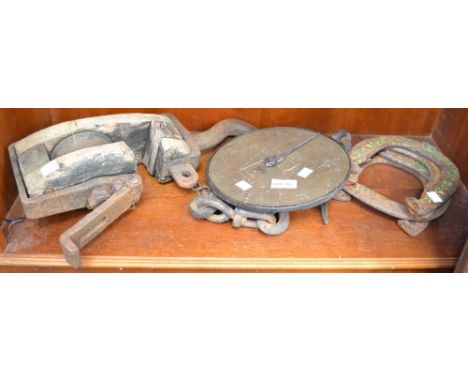 A vintage wood and metal hanging winch with horseshoes brass scale etc