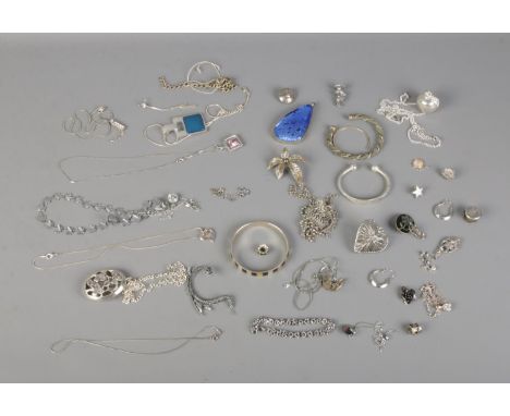 A collection of white metal costume jewellery to include mother of pearl bangle, dragon ear cuff, pendants, earrings, etc.  