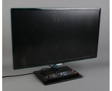 A Samsung 24" TV with remote. Model No. T24D390S.  Scratch to base, some wobble to the base.