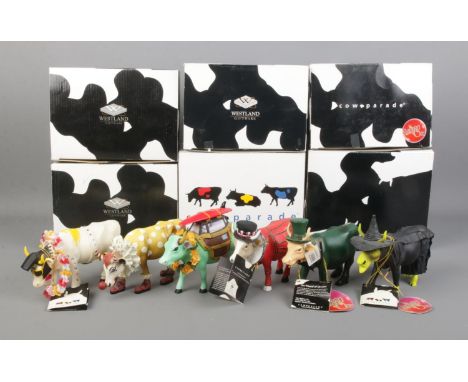 A collection of six Cow Parade ceramic cows, including Cow-A-Bunga!, The Wizard of Oz Cow, Beefeater and Rock N Roll Cow. Wit