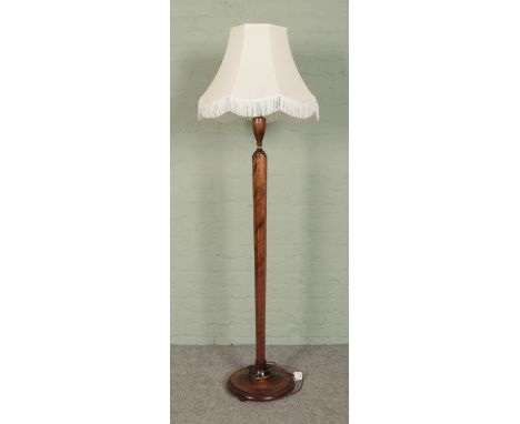 An oak standard lamp, with hexagonal column, baluster top and turned base. With cream frilled shade.  