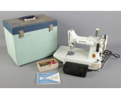 A 1960s white model Singer Featherweight 221K sewing machine with original case and manual.  