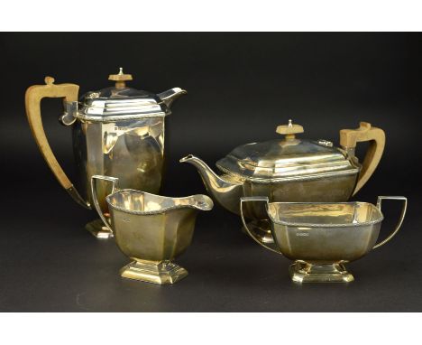 A GEORGE V SILVER FOUR PIECE TEA SERVICE, of rectangular form, cast flower head border, teapot and water jug with brown bakel