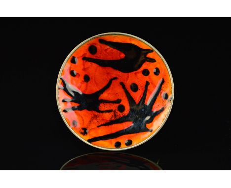 A NORWEGIAN ENAMEL BROOCH BY OYSTEIN BALLE, of circular outline with black enamel pointed shapes and dots on a red/orange ena