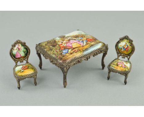 A LATE 19TH/EARLY 20TH CENTURY MINIATURE ENAMEL TABLE AND TWO CHAIRS, cast metal frames, the enamel painted with Watteau styl