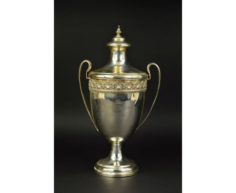 A GEORGE V TWIN HANDLED TROPHY CUP AND COVER, knopped finial over domed cover, the cup with cast rim of anthemion and scroll 