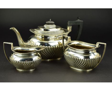 A LATE VICTORIAN SILVER THREE PIECE TEA SERVICE, of oval form, gadrooned rims, reeded decoration, ebony fitments, strap work 