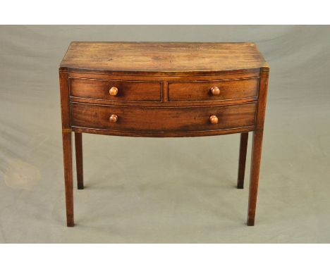 AN EARLY 19TH CENTURY MAHOGANY AND EBONY STRUNG BOW FRONT SIDE TABLE, fitted with two short and one long drawer with turned w