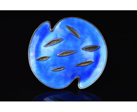 A NORWEGIAN ENAMEL BROOCH BY OYSTEIN BALLE, of shaped circular outline, branch and leaf shapes within the blue enamel backgro
