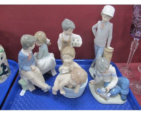 Nao Figurines - Young Boy and Girl on Seat, Boy with Ball, Boy with Puppy and Boy with Train and a Lladro figure of children 