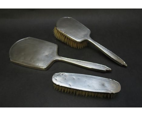 A silver hand mirror and two hairbrushes, marked Birmingham -engine turned design 