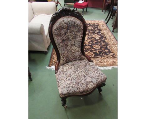 A Victorian carved mahogany and floral armchair on ceramic castors 