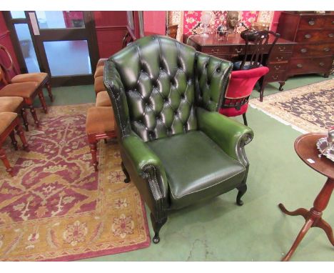 A green leather Chesterfield style button back armchair 