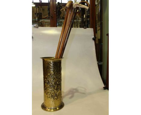 Embossed brass stick stand and four walking sticks