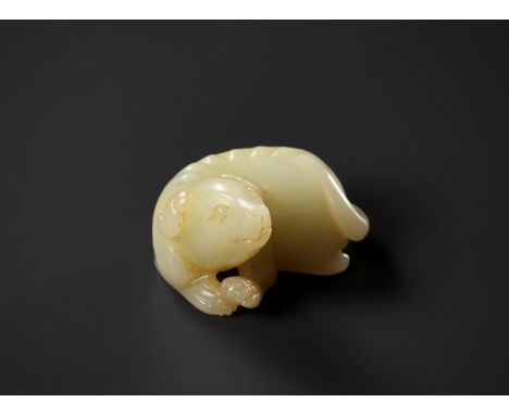 A YELLOW JADE FIGURE OF A DOG, QING DYNASTYChina, 1644-1912. Carved in the form of a recumbent dog, its hind legs tucked unde