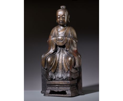 A LARGE BRONZE FIGURE OF A YOUTHFUL DAOIST DEITY, MINGChina, 1368-1644. Seated on a chair with an aperture at the lower front