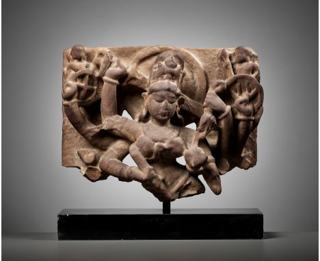 A SANDSTONE FRAGMENT OF DURGA SLAYING MAHISHA, UTTAR PRADESHIndia, 9th-10th century. Carved in openwork as Durga wielding the