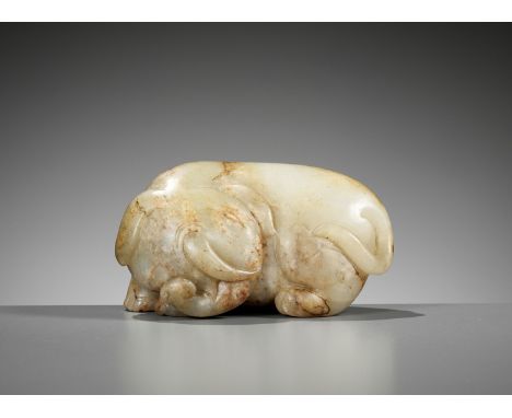 A CELADON AND RUSSET JADE FIGURE OF AN ELEPHANT, MING DYNASTYChina, 1368-1644. The substantial body carved in form of a pebbl