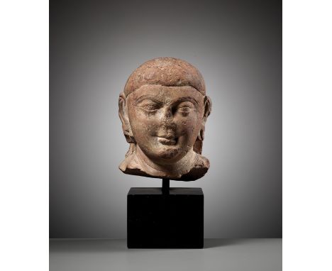 A PINK SANDSTONE HEAD OF BUDDHA, MATHURA, KUSHAN PERIODIndia, Uttar Pradesh, 2nd-3rd century. The head finely carved with a r