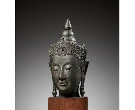 A BRONZE HEAD OF BUDDHA, AYUTTHAYA KINGDOMThailand, 17th-18th century. The face with a serene expression, marked by heavy-lid