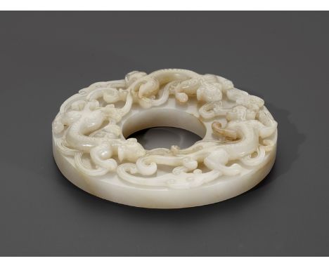 A PALE CELADON AND RUSSET JADE 'CHILONG' DISC, BI, QING DYNASTYChina, 18th-19th century. Finely worked in high relief on one 
