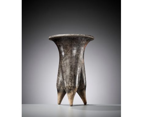 A GRAY POTTERY TRIPOD VESSEL, LI, LOWER XIAJIADIAN CULTUREChina, circa 1500 BC. The beaker shaped vessel with a wide everted 