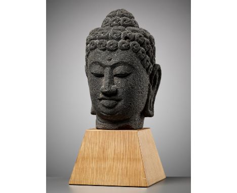 AN ANDESITE HEAD OF BUDDHA, 9TH – 10TH CENTURYIndonesia, Central Java. Finely carved with bow-shaped mouth and downcast eyes 