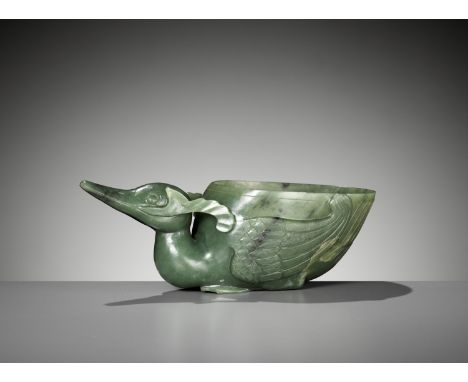 A SPINACH GREEN JADE 'DUCK' LIBATION CUP, QING DYNASTYChina, 19th century. The unusual vessel crisply carved in openwork in t