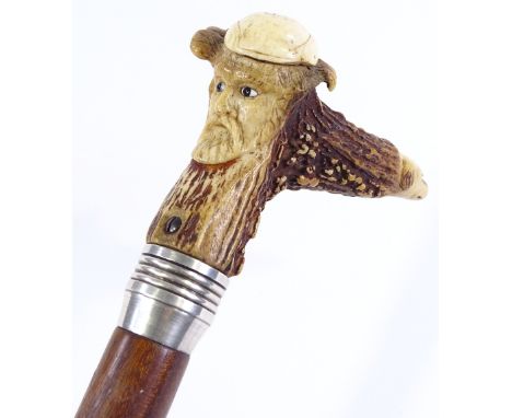 A walking stick with carved mask decorated horn handle 