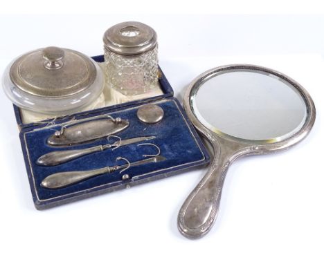 A silver-backed dressing table mirror, a silver powder jar, a manicure set etc 