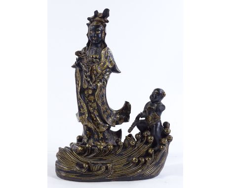 A Chinese gilded and black glaze ceramic figure of Buddha, on wave design base, height 24cm 