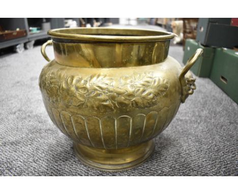 A William Souter &amp; Sons embossed brass planter, with applied mask handles, embossed foliate and fluted decoration