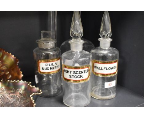 A group of three clear glass chemists bottles, with labels, an R Douglas (London W) bottle and two flared clear glass spill v