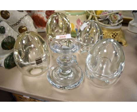 Four glass paraffin burners and a candle stick.