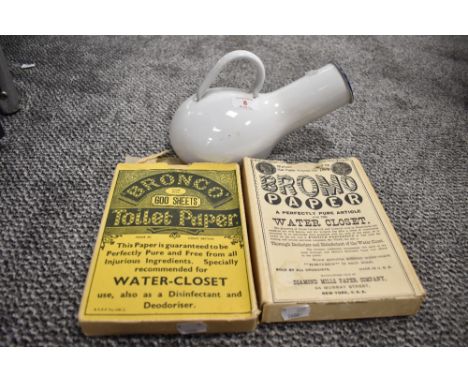 A vintage Swedish 'Kockums' white enamel bed pan and two boxes of vintage toilet paper.