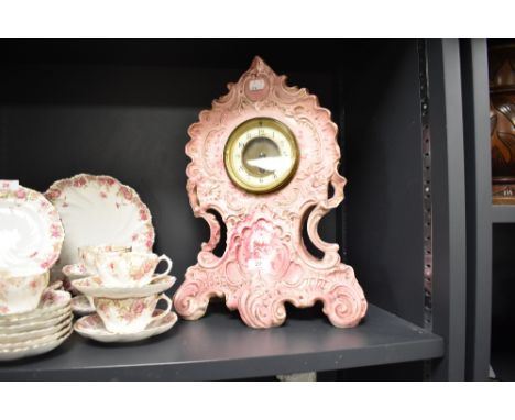 A Victorian puce pottery mantel clock, rocaille-moulded with painted chrysanthemums
