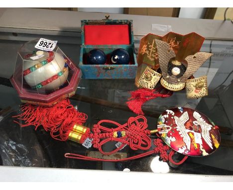A Japanese Samourai 'Kabuko' dolls helmet, a metal and silk sash, an 'Orb-it game and stress balls.