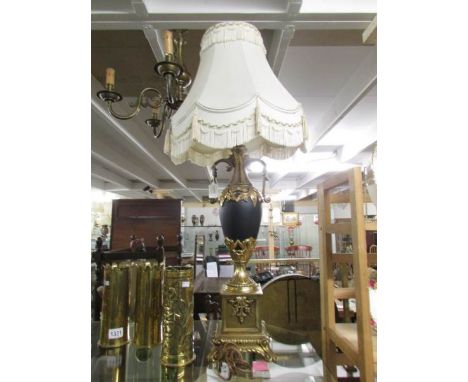 An urn shaped table lamp with gilding and complete with shade.