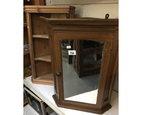 A wall mounted corner shelf unit and 1 corner wall mounted cabinet with mirrored door.