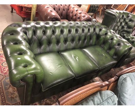 A green leather Chesterfield sofa.