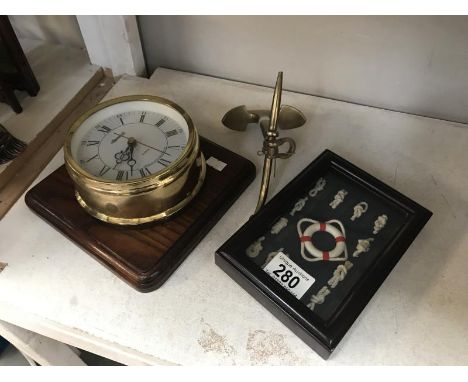 An Ingersoll quarts ship style wall clock, a brass ships anchor and knot display.