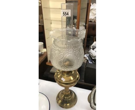 A brass oil lamp with moulded glass shade.